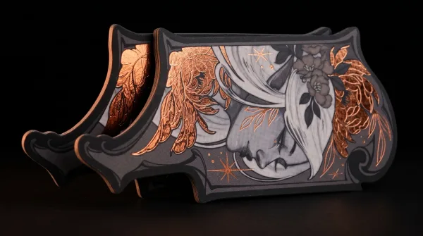 An ornately die-cut card shaped around a copper-foil illustration.