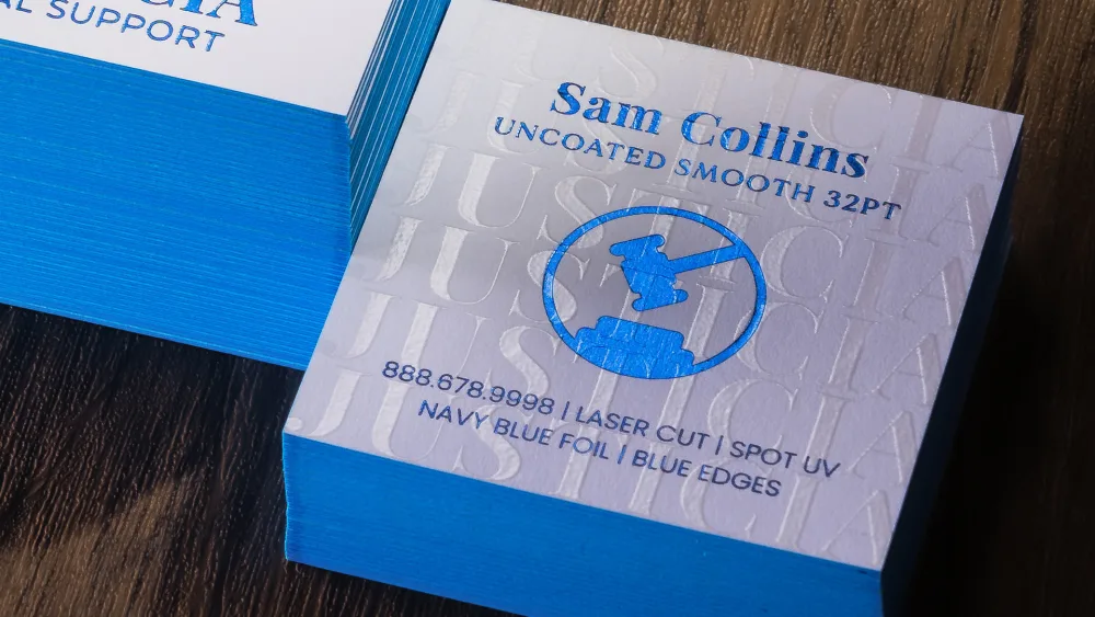 Raised Spot UV business cards — clear dimensional gloss detail built up off the card surface, catching the light.